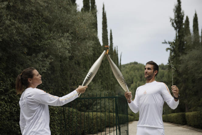 Stefanos Ntouskos of Greece, Olympic rowing champion in Tokyo 2021, passes the flame to Lore Manoudou on April 16, 2024 in Olympia, Greece.  