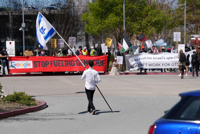 A counter-protester holding an Israeli flag walks into the parking lot near a protest at Google Cloud offices in Sunnyvale, California, US on April 16, 2024.