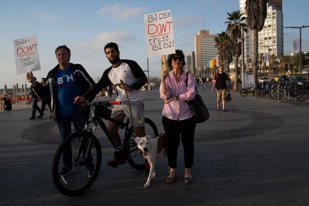 Israeli protesters opposed to Benjamin Netanyahu's policies hold up signs addressing US president Joe Biden, outside the US embassy in Tel Aviv, April 15, 2024.