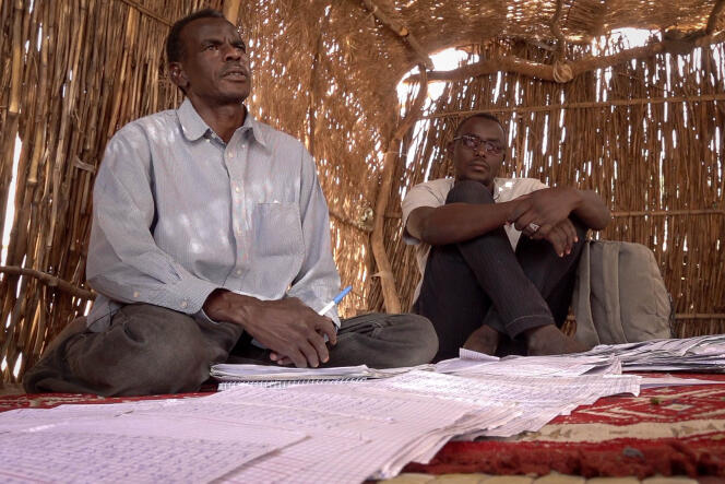 Ahmad Khamis and Abdelmoneim Juzur, from the West Darfur Lawyers' Collective, are busy recording the names, ages and professions of victims on sheets of paper in the refugee camp near Adré, Chad, in April 2024.