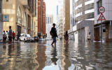 FILE PHOTO: People walk through flood water caused by heavy rains, in Dubai, United Arab Emirates, April 17, 2024. REUTERS/Amr Alfiky/File Photo