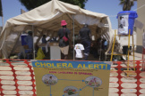 Une famille entre dans une tente réservée aux patients atteints par le choléra dans une clinique à Harare, au Zimbabwe, le 18 novembre 2023. 