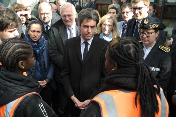 France's Prime Minister Gabriel Attal (C) listens to a member of MJC "Youth and Cultural Centre" ("Maison des jeunes et de la culture" as Viry Chatillon's Mayor Jean Marie Villain (4L), France's Minister for Education and Youth Nicole Belloubet (6L), France's Minister for Justice Eric Dupond-Moretti (3L) and France's Deputy Minister for Children, Youth and Families Sarah El-Hairy (2L) look at, during a visit to mark his 100th day in Matignon, in Viry-Chatillon, south of Paris, on April 18, 2024. (Photo by Bertrand GUAY / POOL / AFP)