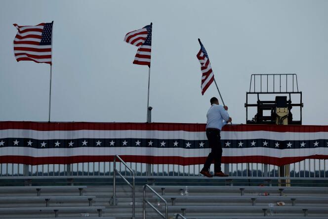 Des membres du personnel retirent les drapeaux américains après le report d'un rassemblement de Donald Trump à Wilmington, en Caroline du Nord, le 20 avril 2024.