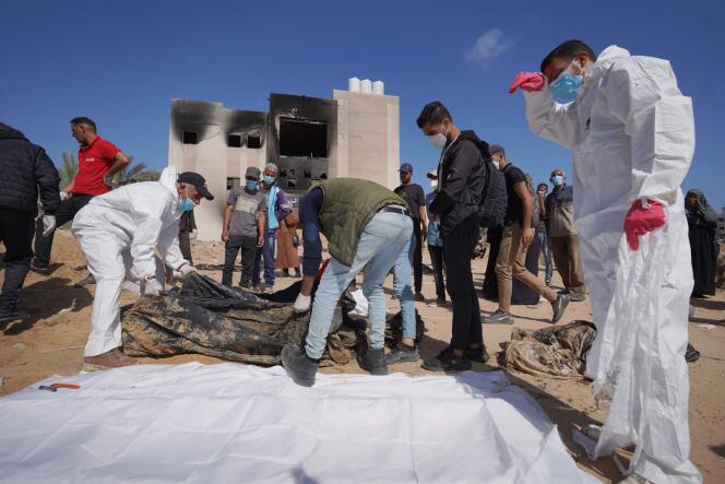 Des sauveteurs palestiniens procèdent à l'exhumation de corps qui auraient été découverts dans l'enceinte de l'hôpital Nasser, à Khan Younes, au sud de la bande de Gaza, le 21 avril 2024. 