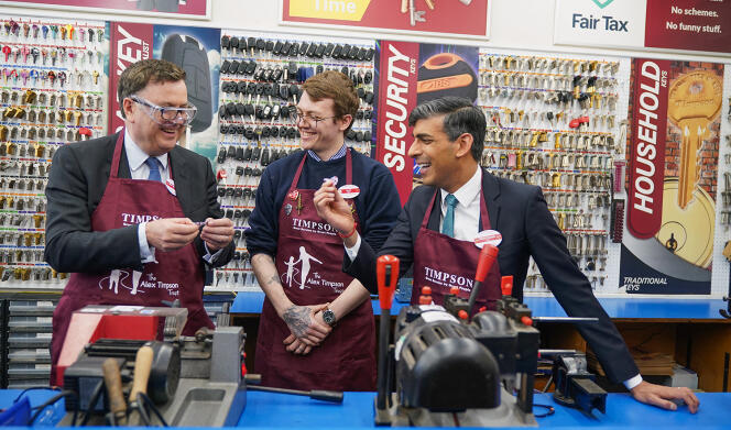 Le 19 avril, à Londres, Rishi Sunak (à droite) dans une boutique de la chaîne de magasins multiservices Timpson, avec le secrétaire au travail et aux pensions, Mel Stride (à gauche), et le directeur du magasin, Jack Randall (au centre).