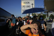 People wait in the heat at a bus stop in Quezon, Philippines, April 15, 2024.