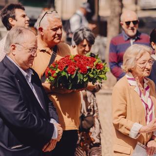 Group of people celebrating 25 de Abril, and pay homage to Vasco Correia and Natércia. Ceremony included singing 