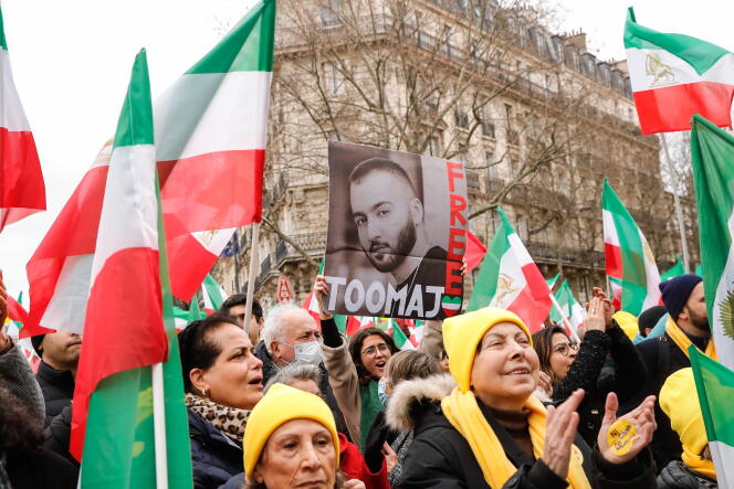 Une femme tient un portrait du rappeur Toomaj Salehi, à l’occasion du 44ᵉ anniversaire de la révolution, à Paris, le 12 février 2023.