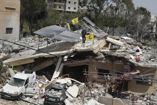 Un homme se tient sur une maison qui a été détruite par une frappe aérienne israélienne, dans le village de Hanine, au sud du Liban, le jeudi 25 avril 2024.