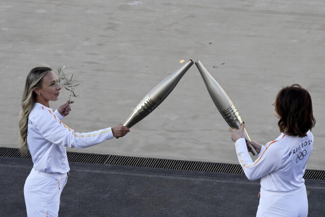 Greek Olympic gold medalist Antigoni Ntrismpioti, left, and Gabriella Papadakis, French Olympic champion ice dancer pass the Olympic Flame during the Olympic flame handover ceremony at Panathenaic stadium, where the first modern games were held in 1896, in Athens, on Friday, April 26, 2024.
