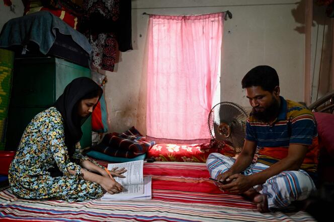 Un homme et sa fille, dont les cours se déroulent à distance, dans leur maison, à Dacca (Bangladesh), le 25 avril 2024.