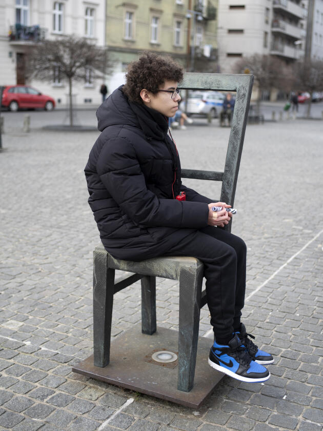 Nazim, éleve de 3ᵉ-5, sur la place des Héros du Ghetto, monument commémoratif composé de 68 chaises vides symbolisant les 68 000 Juifs disparus, à Cracovie (Pologne), le 27 février 2024.