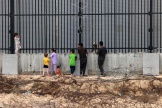 Des déplacés palestiniens discutent avec un soldat égyptien à la frontière entre l’Egypte et la bande de Gaza, à Rafah, le 26 avril 2024.