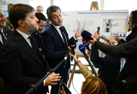 France's Minister for Interior and Overseas Gerald Darmanin (R) talks to the press in front of a map during a visit to oversee preparations ahead of the Olympic torch arrival in Marseille, southern France, on April 26, 2024. Before entering the Vieux-Port, the Belem will parade through Marseille's harbor, accompanied by 1,024 boats, as some 150,000 people are expected to welcome it on May 8, 2024 with entertainment planned on land and at sea throughout the day. (Photo by CHRISTOPHE SIMON / AFP)