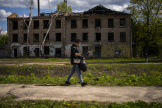 Un jeune garçon passe devant un bâtiment partiellement détruit par des attaques russes à Borodianka, au nord de Kiev, le 27 avril 2024.