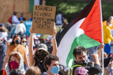 Pro-Palestinian supporters hold up a sign and flag inside an encampment on the UCLA campus April 26, 2024, in Los Angeles. 
