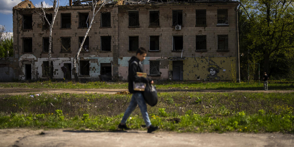 Un jeune garçon passe devant un bâtiment partiellement détruit par des attaques russes à Borodyanka, en Ukraine, le 27 avril 2024.