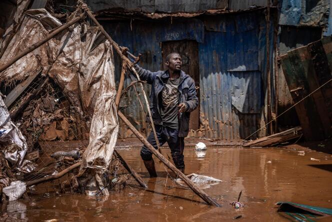 2024 年 4 月 25 日，内罗毕马萨雷社区暴雨过后，一名男子正在从被洪水淹没的地区搬运材料。