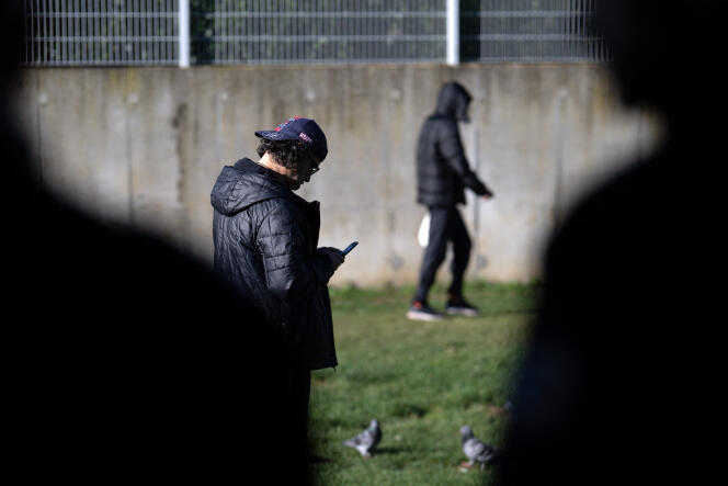 Des policiers français surveillent des migrants lors de leur promenade dans la cour du Centre de rétention administrative de Vincennes, le 2 novembre 2023.