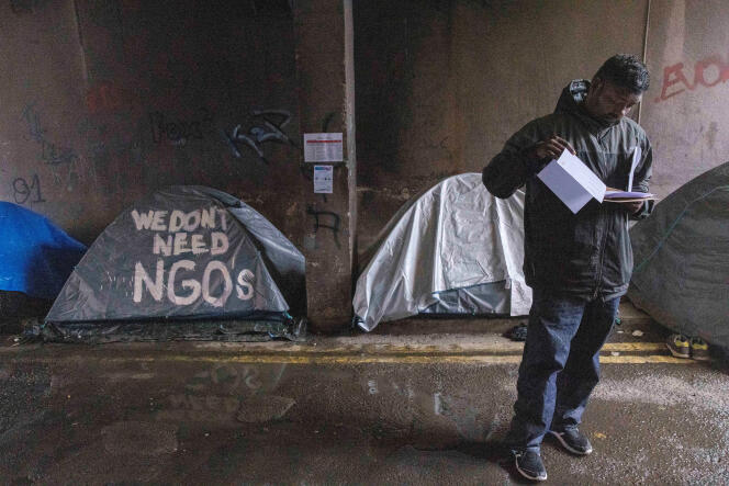 Un demandeur d’asile examine ses documents après un rendez-vous Bureau de la protection internationale (IPO), autour duquel des centaines de migrants dorment dans la rue sous des tentes, depuis plusieurs mois, à Dublin, le 30 avril 2024.