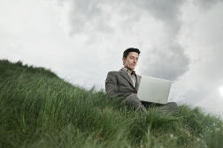 Homme d’affaires utilisant un ordinateur portable dans le champ