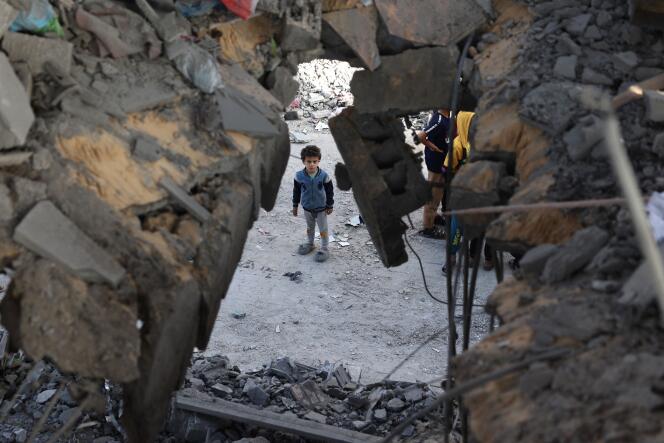 A Palestinian child stands in front of a building destroyed by Israeli bombing in Rafah in the southern Gaza Strip on May 3, 2024.