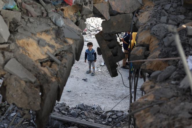 A Palestinian child stands in front of a building destroyed by Israeli bombing in Rafah in the southern Gaza Strip on May 3, 2024.