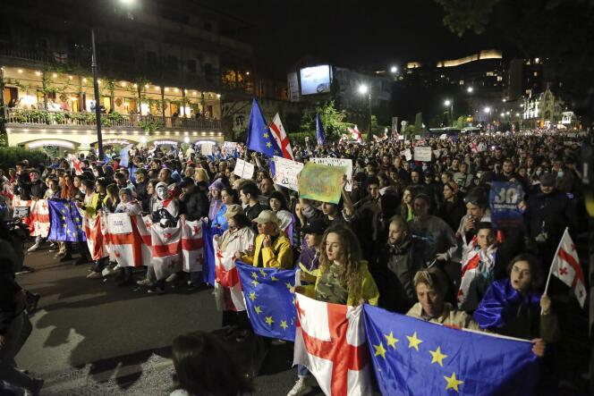 I manifestanti che portano le bandiere nazionali georgiane ed europee marciano contro 