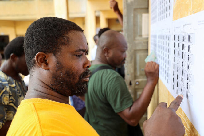 A man searches for his name on a voters list put up on a wall, during the Togo's parliamentary and regional elections in Lomé, on April 29, 2024.