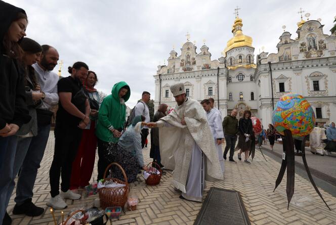 Orthodox devotees stand next to baskets of traditional Easter delights as they are blessed by a Ukrainian priest outside the Assumption Cathedral of the Kyiv Pechersk Lavra in Kyiv, on May 5, 2024, amid the Russian invasion in Ukraine. 
