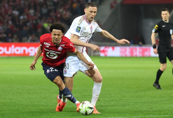 Lille defender Tiago Santos (red shirt) battles with Lyon midfielder Nemanja Matic, at the Pierre-Mauroy stadium in Villeneuve-d'Ascq, May 6, 2024.