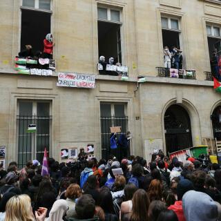 Demonstrators take part in a gathering in front of the Institute of Political Studies (Sciences Po Paris) as students occupy a building, with a barricade blocking the entrance, in support of Palestinians, in Paris on April 26, 2024. A few dozen students stay mobilized in support of Palestinians occupying a new building at Sciences Po Paris since April 25, 2024, evening, the day after police evacuated another of the school's sites, in the wake of actions at American universities.
 (Photo by Dimitar DILKOFF / AFP)