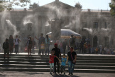 Des personnes sous des brumisateurs, sur la place Gerardo Barrios, à San Salvador, le 27 mars 2024.