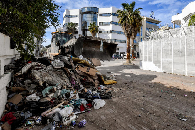 Devant le siège de l’Organisation internationale pour les migrations (OIM) à Tunis le 3 mai 2024, un bulldozer dégage les débris d’un campement de migrants après son évacuation forcée.