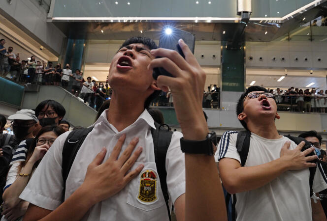 Des Hongkongais chantent « Gloire à Hongkong », chanson écrite par des manifestants, dans un centre commercial, à Hongkong le 11 septembre 2019.