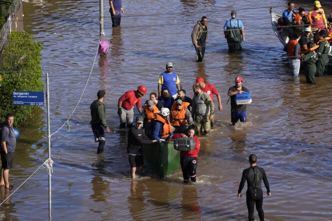 Pessoas evacuam área inundada por fortes chuvas em Porto Alegre, Rio Grande do Sul, Brasil, 9 de maio de 2024.