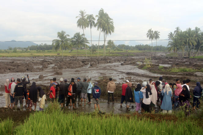 Des gens inspectent une zone touchée par la crue soudaine qui a tué plusieurs personnes à Agam, dans l'ouest de Sumatra, en Indonésie, le dimanche 12 mai 2024. 
