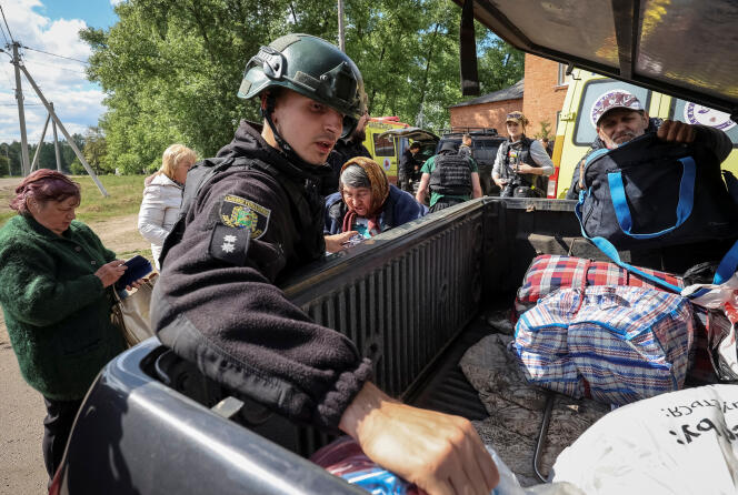 Un oficial de policía ayuda a los residentes del oblast de Kharkiv, en el este de Ucrania, a evacuar ante la ofensiva rusa, el domingo 12 de mayo de 2024.