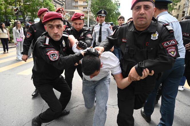 Armenian law enforcement officers detain a demonstrator in a protest against land transfer to neighbouring Azerbaijan, in Yerevan on May 13, 2024. 