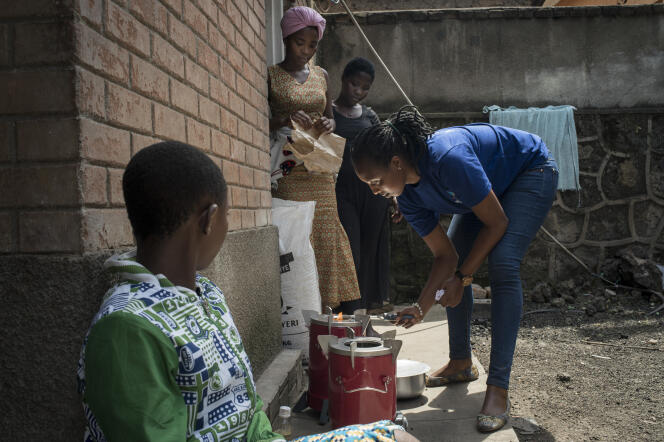 Une employée de l’entreprise Inyenyeri explique à des clients comment utiliser un poêle, à Gisenyi (Rwanda), le 1ᵉʳ octobre 2018.
