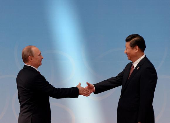 Le président russe Vladimir Poutine accueilli par le président chinois Xi Jinping avant la cérémonie d’ouverture au Centre des expositions lors du quatrième sommet de la Conférence sur l’interaction et les mesures de renforcement de la confiance en Asie (CICA) à Shanghaï, le 21 mai 2014.