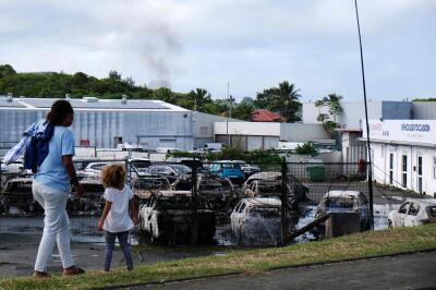 Des voitures brûlées chez un concessionnaire automobile dans le quartier de Belle-Vie, à Nouméa, le 14 mai 2024.