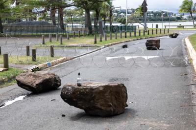 Des barbelés et des pierres bloquent une sortie du quartier Tuband, à Nouméa, en Nouvelle-Calédonie, le 15 mai 2024.