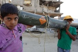 Deux enfants palestiniens transportent un reste de munition américaine, à Khan Younès, dans la bande de Gaza, le 16 mai 2024.