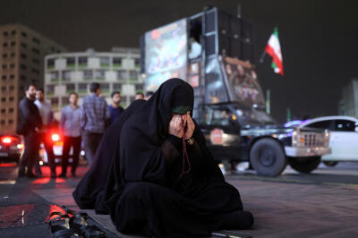 Dans les rues de Téhéran, une femme prie pour le président Ebrahim Raïssi, dans la nuit du 19 mai 2024. 