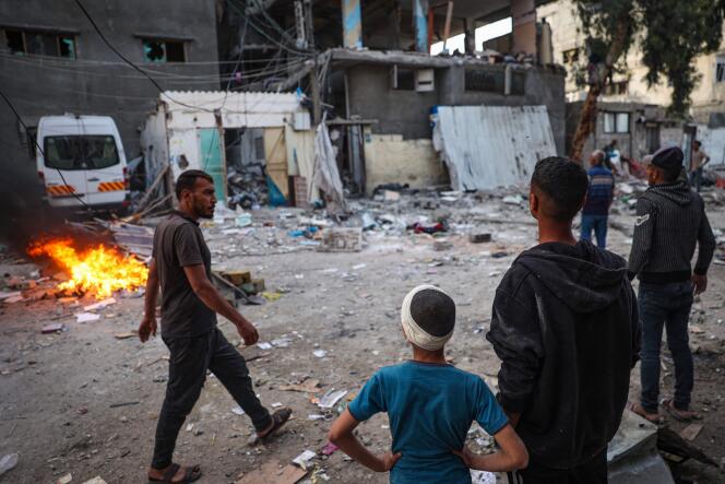 Palestinos frente a las ruinas de una casa alcanzada durante la noche por un bombardeo israelí, el 20 de mayo de 2024, en un barrio de Rafah, en el sur de la Franja de Gaza.