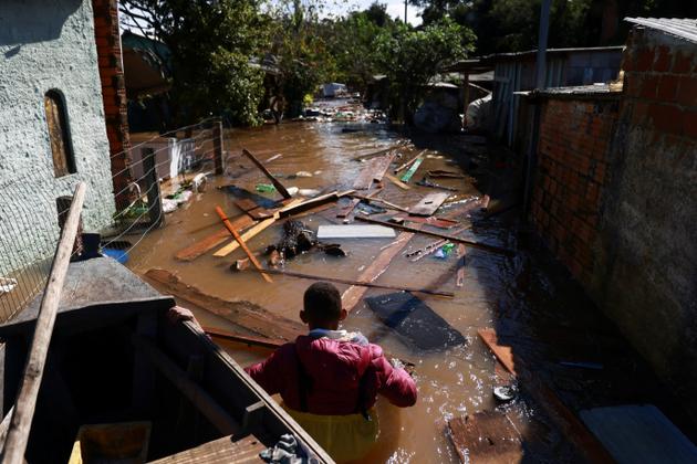 A man stands near debris and objects from his house in Serraria, Porto Alegre (Brazil), May 14, 2024.