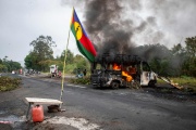 A Kanak flag next to a burning vehicle at a pro-independence roadblock at La Tamoa, in France's overseas territory of New Caledonia on May 19, 2024.