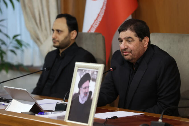 Le premier vice-président iranien, Mohammad Mokhber (à droite), derrière un portrait du président Ebrahim Raïssi (portrait), à Téhéran, le 20 mai 2024.